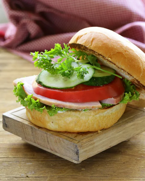 Hamburger snack con verdure fresche e prosciutto su una tavola di legno — Foto Stock