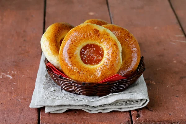 Round sweet buns with apple jam in a wicker basket — Stock Photo, Image
