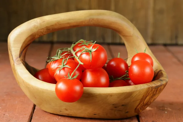 Tomates orgânicos maduros frescos em uma mesa de madeira — Fotografia de Stock