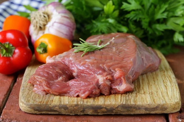 Bistecca di manzo cruda con ingredienti verdure su una tavola di legno — Foto Stock