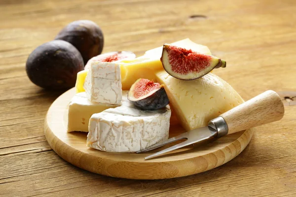 Cheeseboard with maasdam, camembert, cheddar cheese and figs — Stock Photo, Image