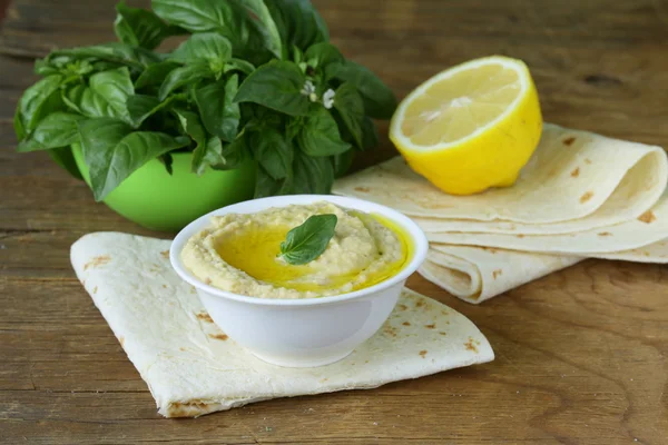 Hummus tradicional de garbanzo con pan de pita en una mesa de madera — Foto de Stock