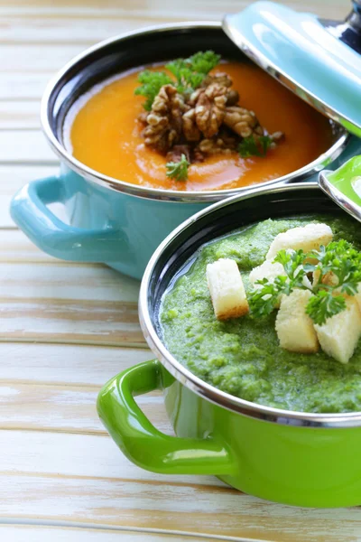 两种奶油汤 （西兰花和南瓜） 在锅上木制的背景 — 图库照片