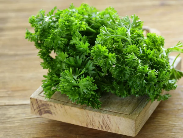 Świeży zielony organiczny pietruszka na drewnianym stołem — Zdjęcie stockowe