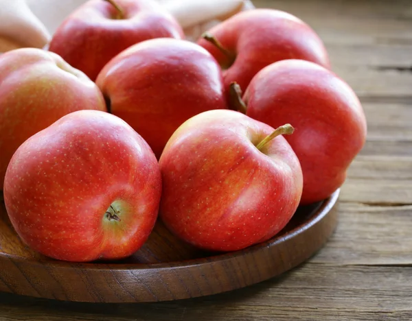 Manzanas rojas maduras cosecha de otoño en un plato de madera —  Fotos de Stock