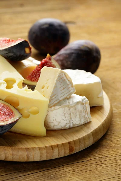 Cheeseboard with maasdam, camembert, cheddar cheese and figs — Stock Photo, Image