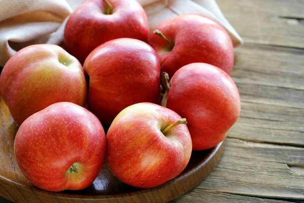 Pommes rouges mûres récolte d'automne sur une assiette en bois — Photo