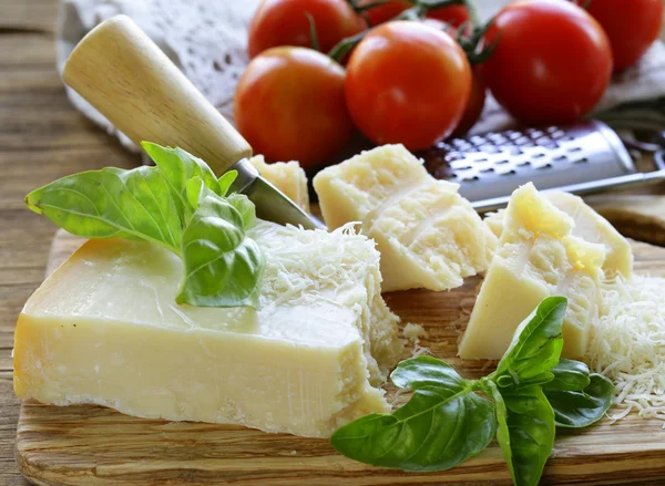 Queijo de parmesão duro saboroso fresco em uma tábua de madeira — Fotografia de Stock