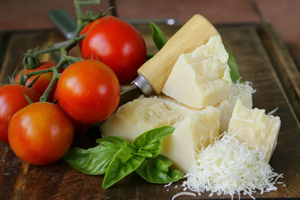 Queijo de parmesão duro saboroso fresco em uma tábua de madeira — Fotografia de Stock