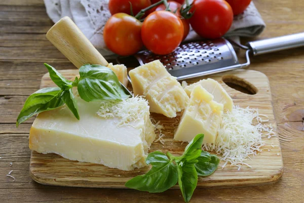 Queso parmesano duro fresco y sabroso sobre una tabla de madera —  Fotos de Stock