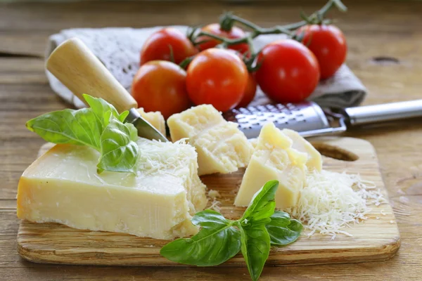 Свежий вкусный твердый сыр пармезан на деревянной доске — стоковое фото