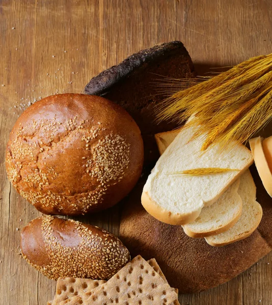 Assortimento di pane (segale, frumento integrale, per toast) su fondo di legno — Foto Stock
