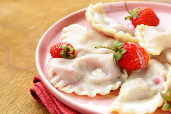 Dumplings met bessen en crème saus geserveerd met verse aardbeien — Stok fotoğraf