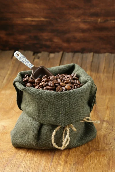 Roasted coffee beans in a bag with ceramic scoop — Stock Photo, Image