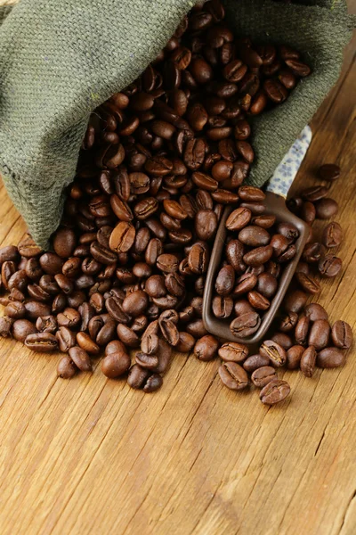 Roasted coffee beans in a bag with ceramic scoop — Stock Photo, Image
