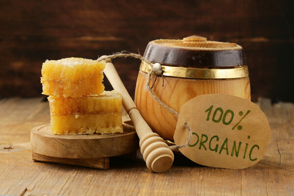 Естественный органический мед в расческе на деревянном фоне

