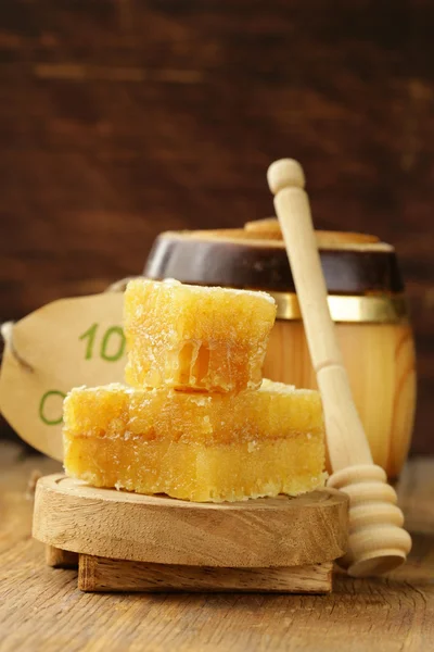 Přírodní bio med v hřeben na dřevěné pozadí — Stock fotografie