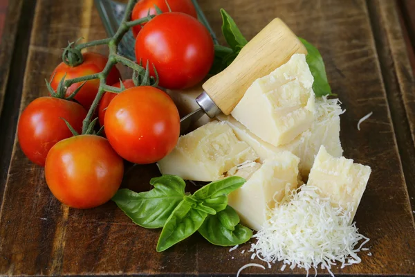 Свежий вкусный твердый сыр пармезан на деревянной доске — стоковое фото