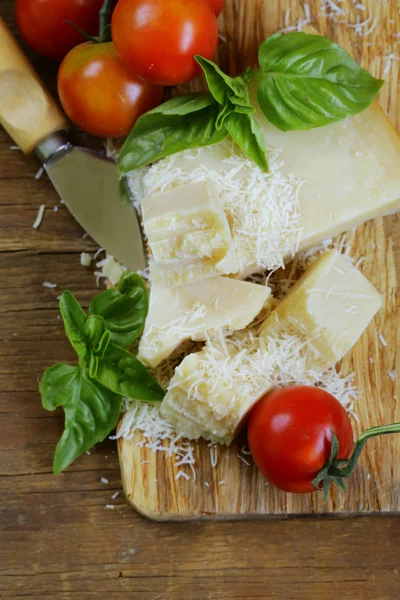 Queijo de parmesão duro saboroso fresco em uma tábua de madeira — Fotografia de Stock