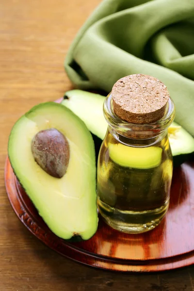 Aceite de aguacate y fruta fresca sobre mesa de madera —  Fotos de Stock