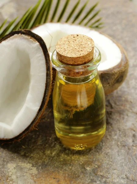 Coconut oil in a glass bottle and fresh nuts — Stock Photo, Image