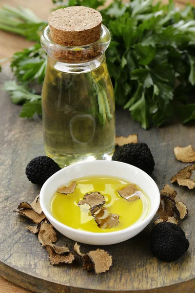 Olive oil flavored with black truffle on a wooden table — Stock Photo, Image