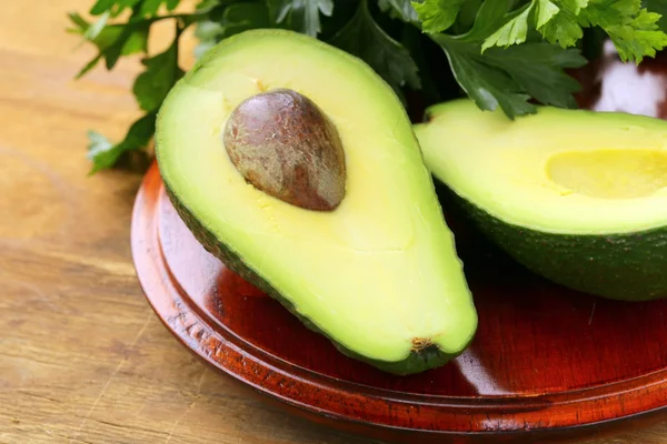 Avocado fresco biologico maturo su un tavolo di legno — Foto Stock