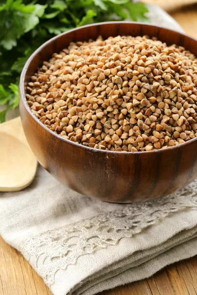 Semole crude di grano saraceno in una ciotola di legno sul tavolo — Foto Stock