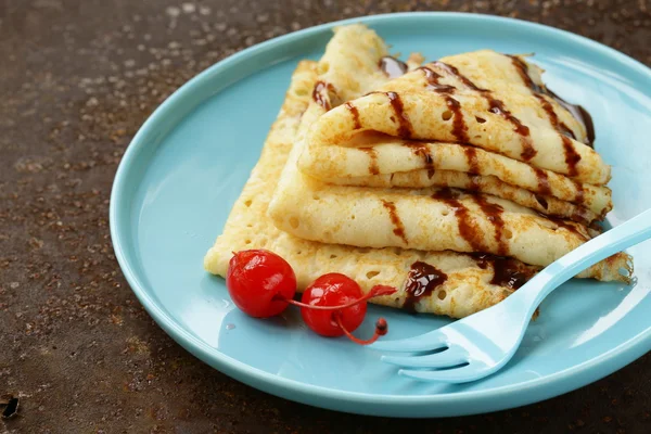 Thin pancakes with chocolate sauce on a plate — Stock Photo, Image