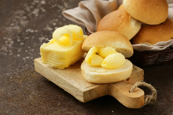 Yellow dairy butter on a fresh bun bread for breakfast