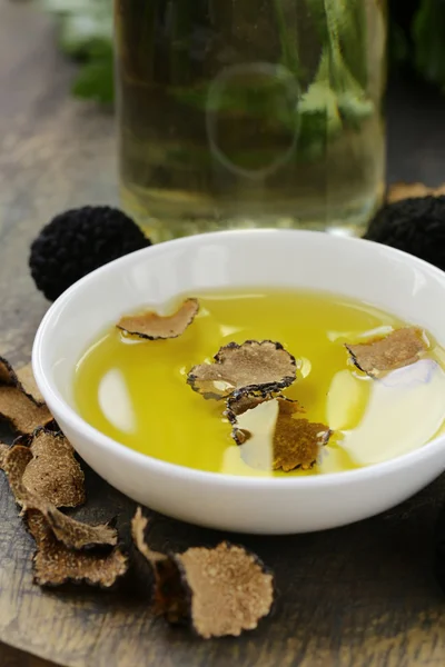 Olive oil flavored with black truffle on a wooden table — Stock Photo, Image