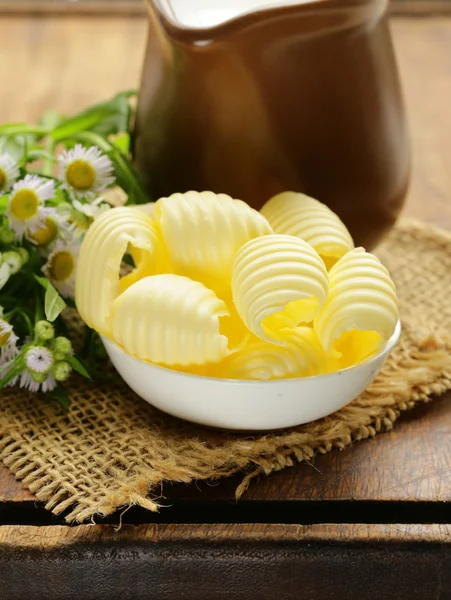 Manteiga amarela fresca servida numa tábua de madeira — Fotografia de Stock