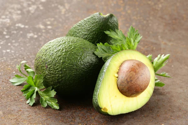 Aguacate fresco orgánico maduro con hojas de perejil — Foto de Stock