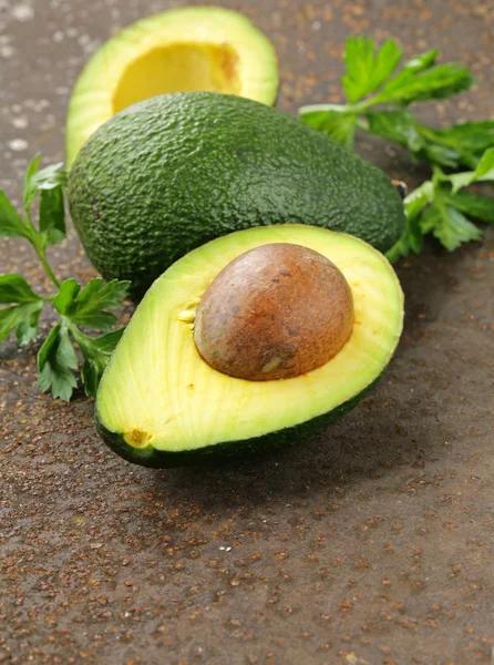 Verse organische rijpe avocado met bladeren van peterselie — Stockfoto