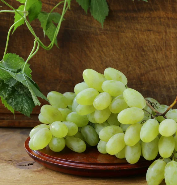 Свежий органический зеленый виноград на деревянном столе — стоковое фото