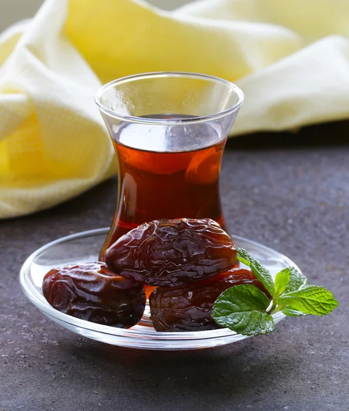 Türkischer Tee im traditionellen Glas mit süßen Datteln — Stockfoto