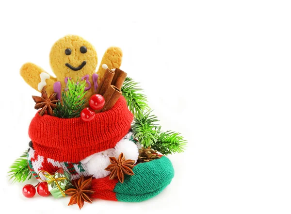 Lebkuchenmann und weihnachtliche Gewürze in Stricksocken auf weißem Hintergrund — Stockfoto