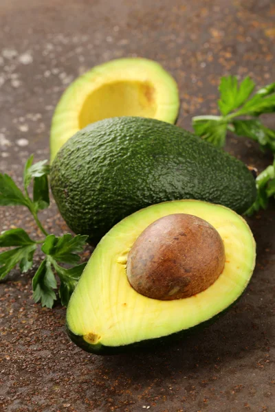 Verse organische rijpe avocado met bladeren van peterselie — Stockfoto