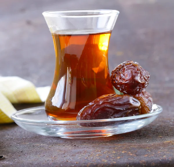 Türkischer Tee im traditionellen Glas mit süßen Datteln — Stockfoto