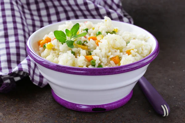 Decorar arroz com vários legumes (cenouras, milho e ervilhas verdes ) — Fotografia de Stock