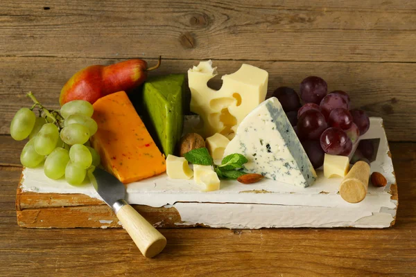 Cheeseboard with different types of cheese and grapes — Stock Photo, Image