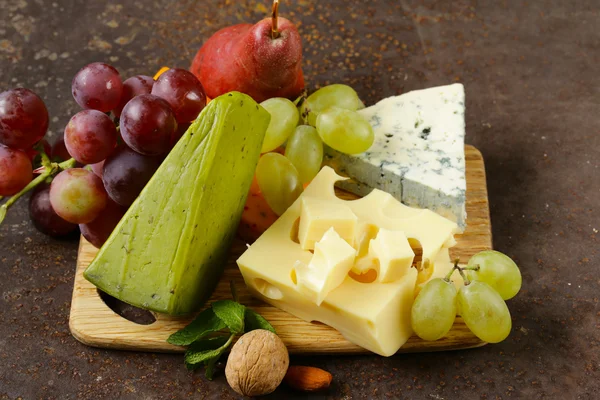 Tabla de quesos con diferentes tipos de queso y uvas —  Fotos de Stock