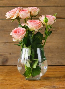 Ahşap bir masa üzerinde pembe gül buketi