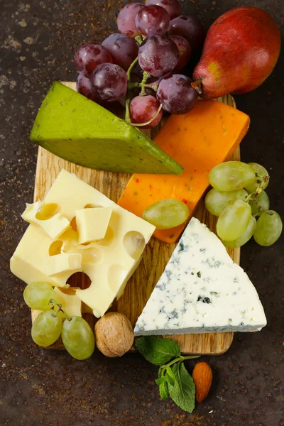 Cheeseboard with different types of cheese and grapes — Stock Photo, Image