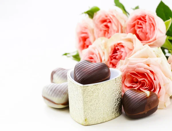 Dulces de chocolate en forma de corazones y rosas rosadas para las vacaciones de San Valentín —  Fotos de Stock