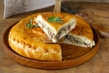 Homemade meat pie with potatoes and oregano clipart