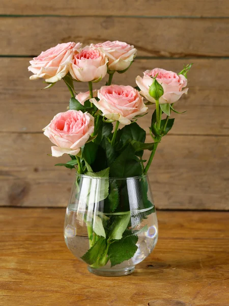 Buquê de rosas rosa em uma mesa de madeira — Fotografia de Stock