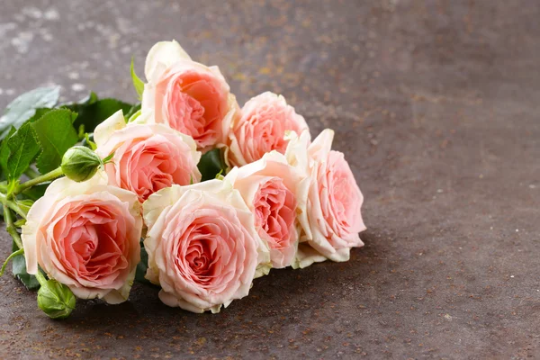 Boeket van roze rozen op een houten tafel — Stockfoto