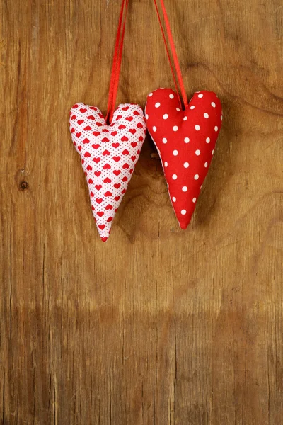 Coloridos corazones de tela hechos a mano sobre un fondo de madera —  Fotos de Stock