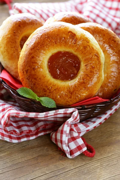 Bollos dulces redondos con mermelada de manzana en una canasta de mimbre — Foto de Stock